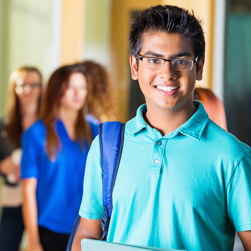 Male student in school smiling at camera