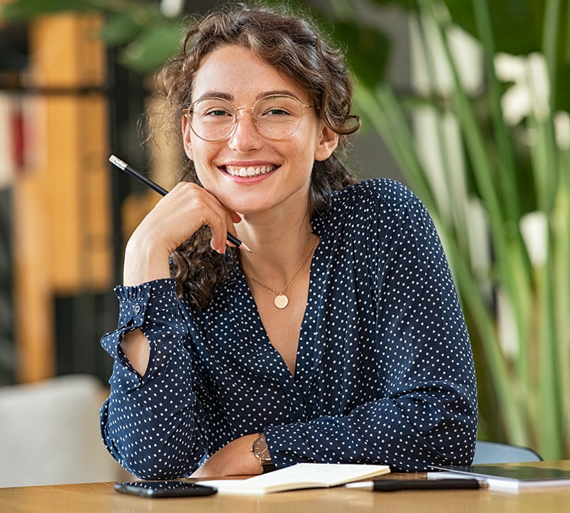 Womeon looking at the camera with a pen in her hand